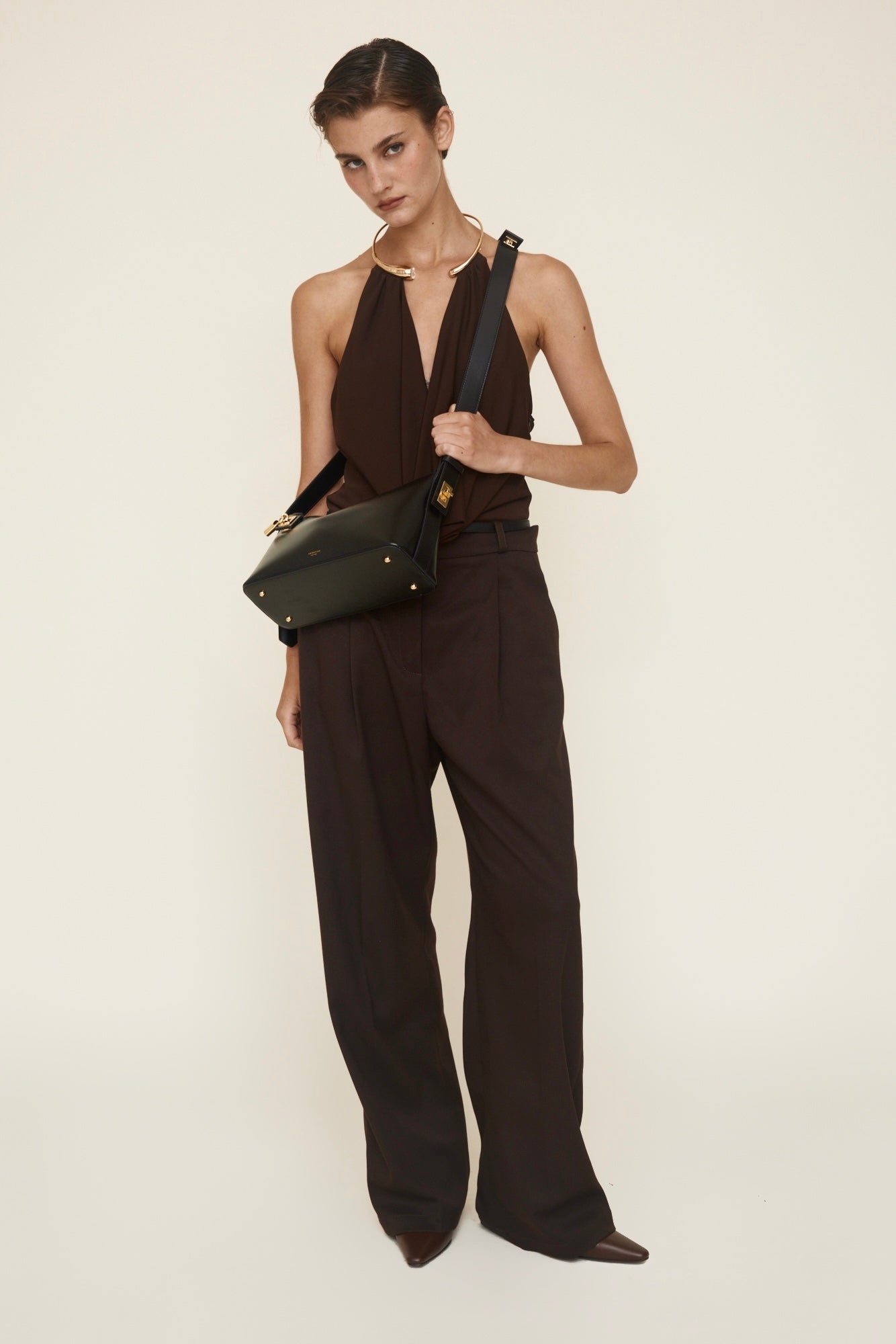 Woman in a brown outfit holding a Gold Black Hobo Shoulder Handbag against a white background