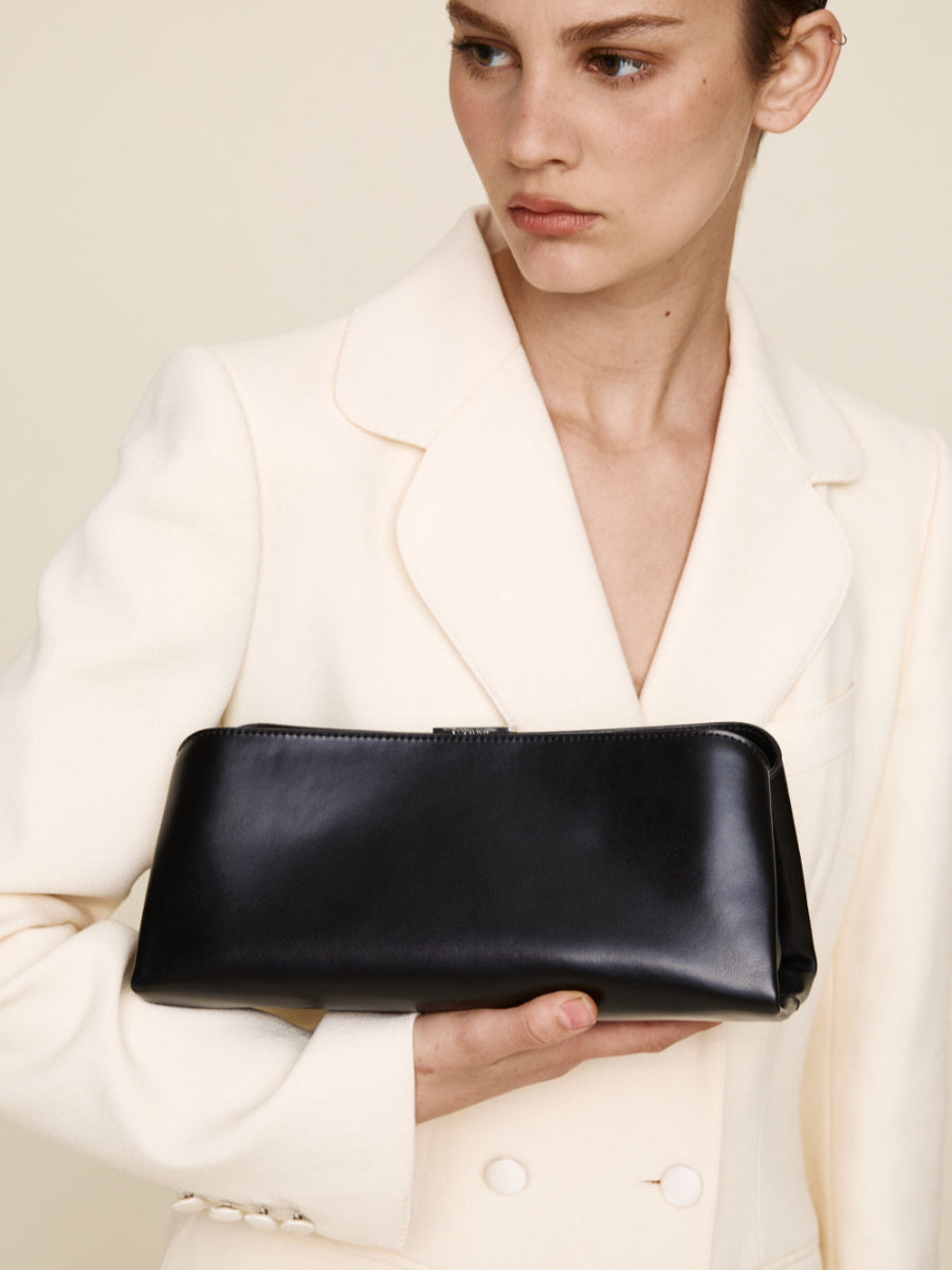 Person holding a Silver Noir Éclair Clutch Shoulder Handbag (Black)  against a neutral background