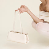 Woman holding a Silver Ivory Éclair Bag: White Clutch Handbag against a plain background