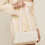 Person holding a Gold Ivory Éclair Bag: White Clutch Handbag against a neutral background