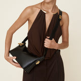 Woman holding a Gold Black Hobo Shoulder Handbag against a neutral background
