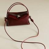 Maroon Python Café Mini Bag: Crossbody Handbag with a strap on a beige background