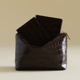 Mocha Croc Makeup Pouch bag on a beige background