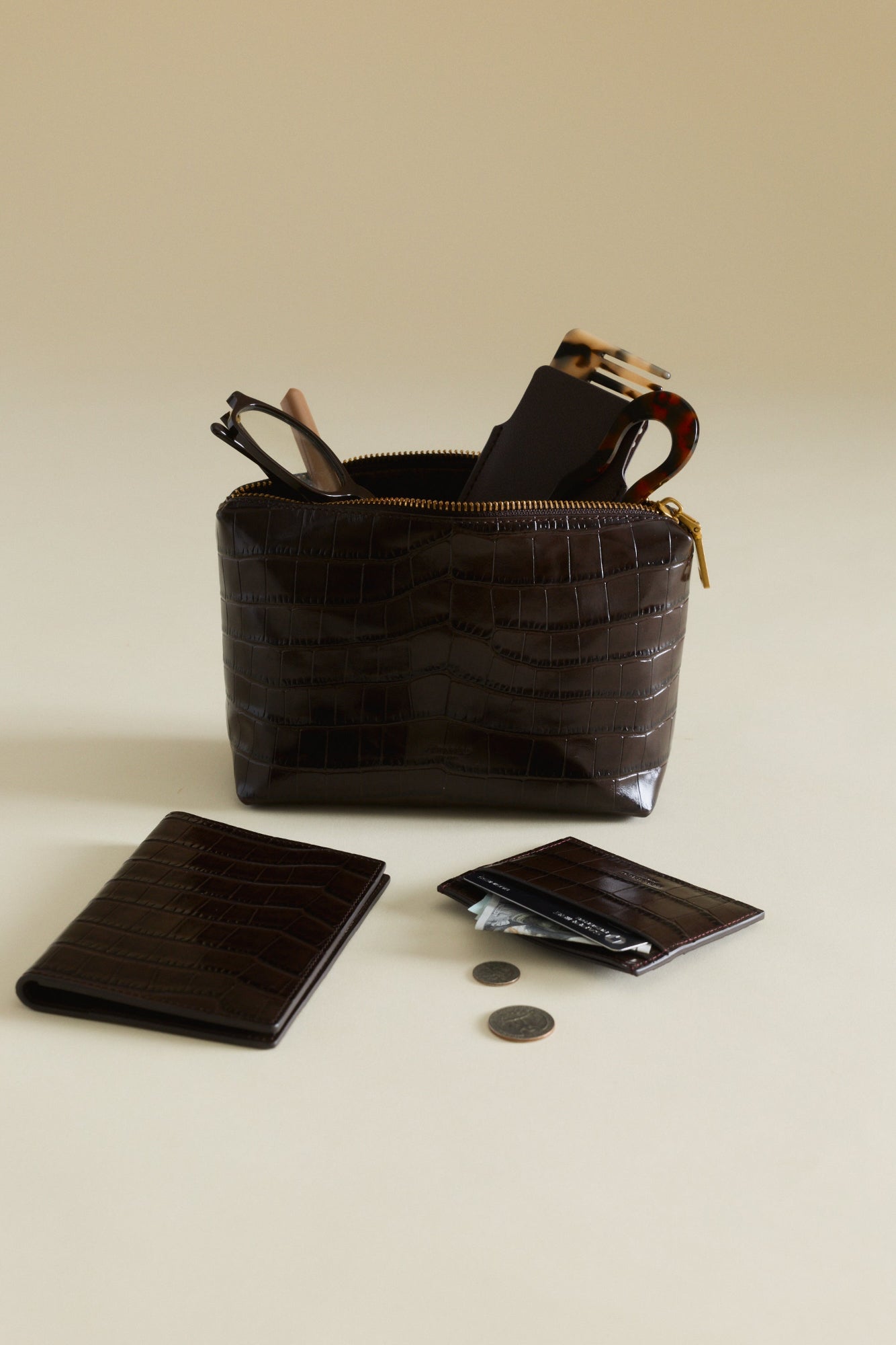 Mocha Croc Makeup Pouch with accessories on a beige background
