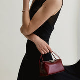 Woman holding a Maroon Python Café Mini Bag: Crossbody Handbag against a plain background