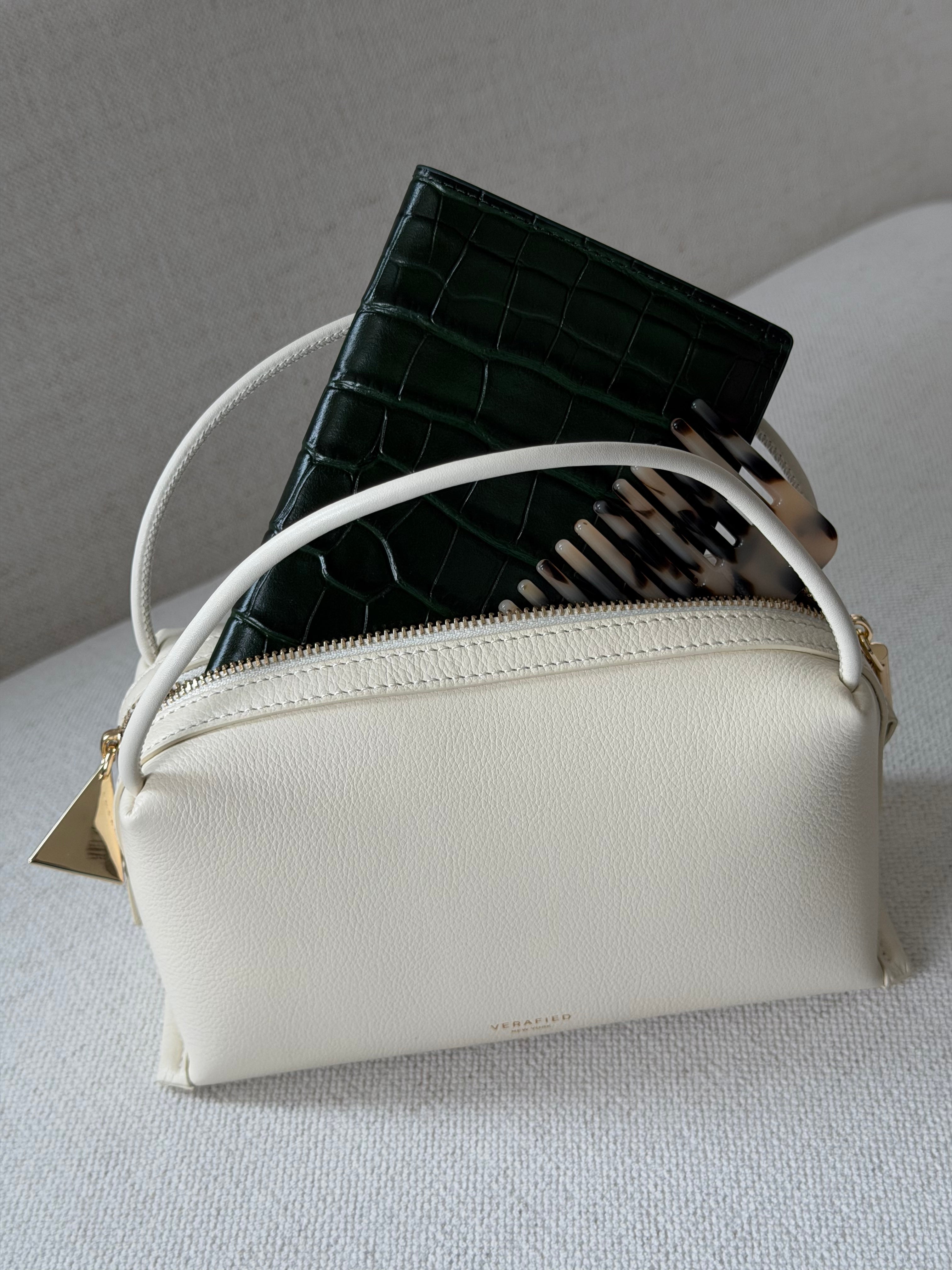 White Ivory Café Mini Crossbody Handbag with a black textured bag underneath on a light gray background