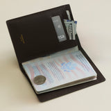 Mocha Croc Embossed Passport Cover Wallet with passport, money, and card on a light beige background