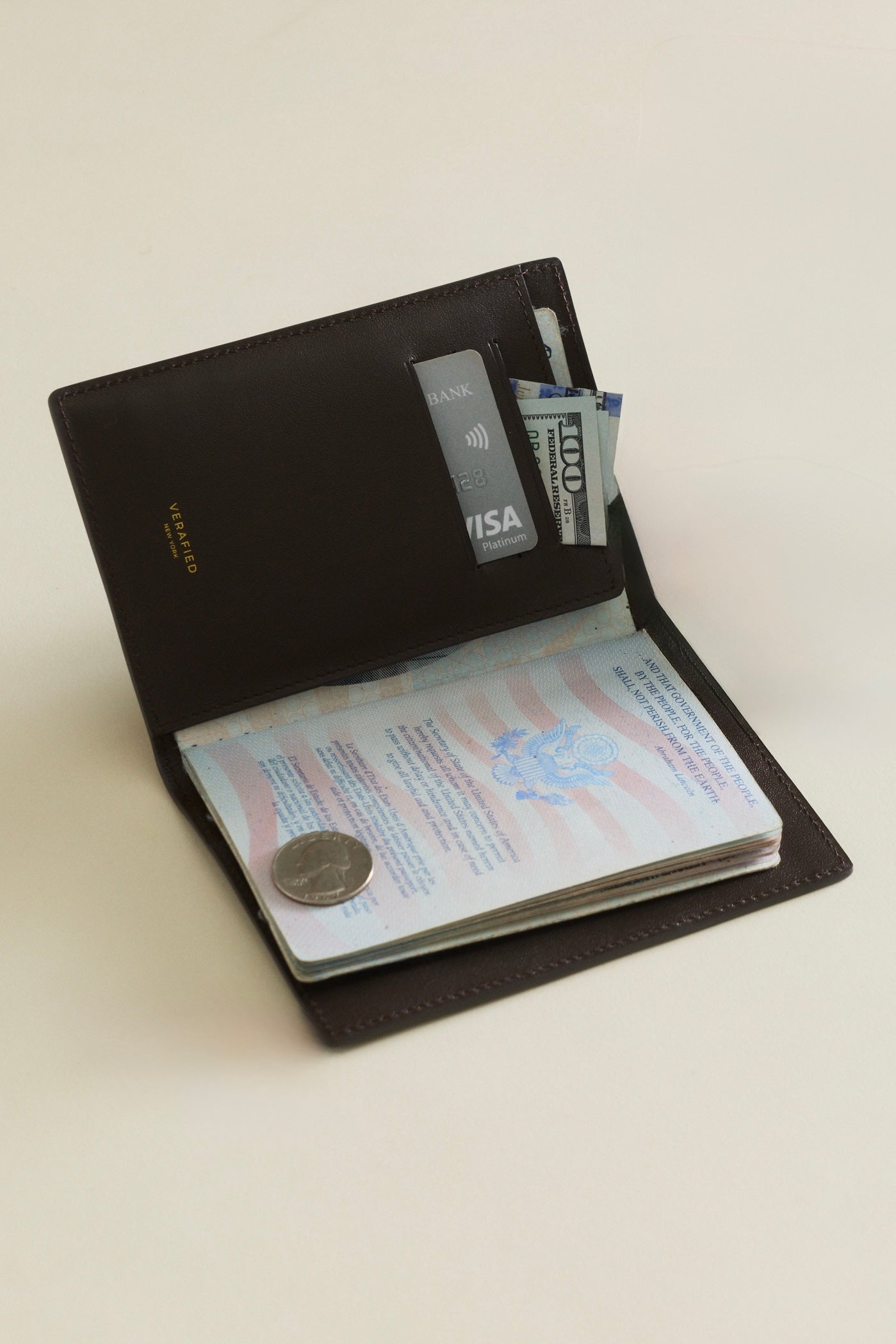 Mocha Croc Embossed Passport Cover Wallet with passport, money, and card on a light beige background