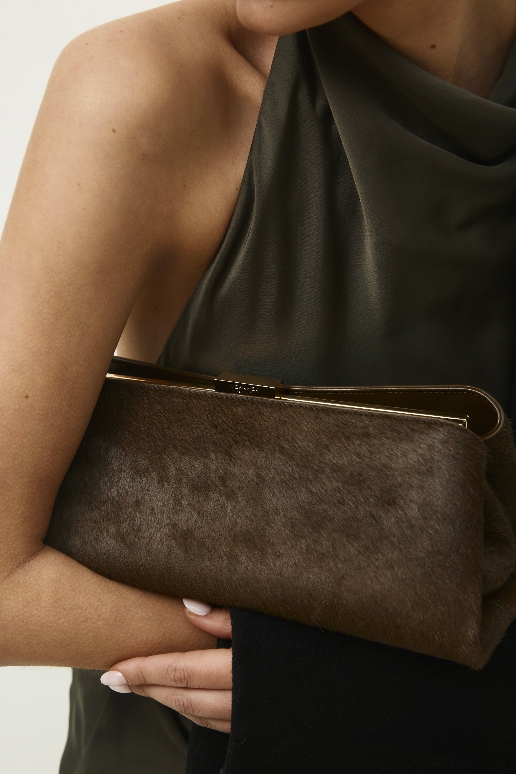 Olive Calf Hair Clutch Shoulder Handbag held by a person wearing a green dress against a neutral background