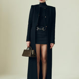 Woman in a black outfit holding a Olive Calf Hair Clutch Shoulder Handbag against a plain background